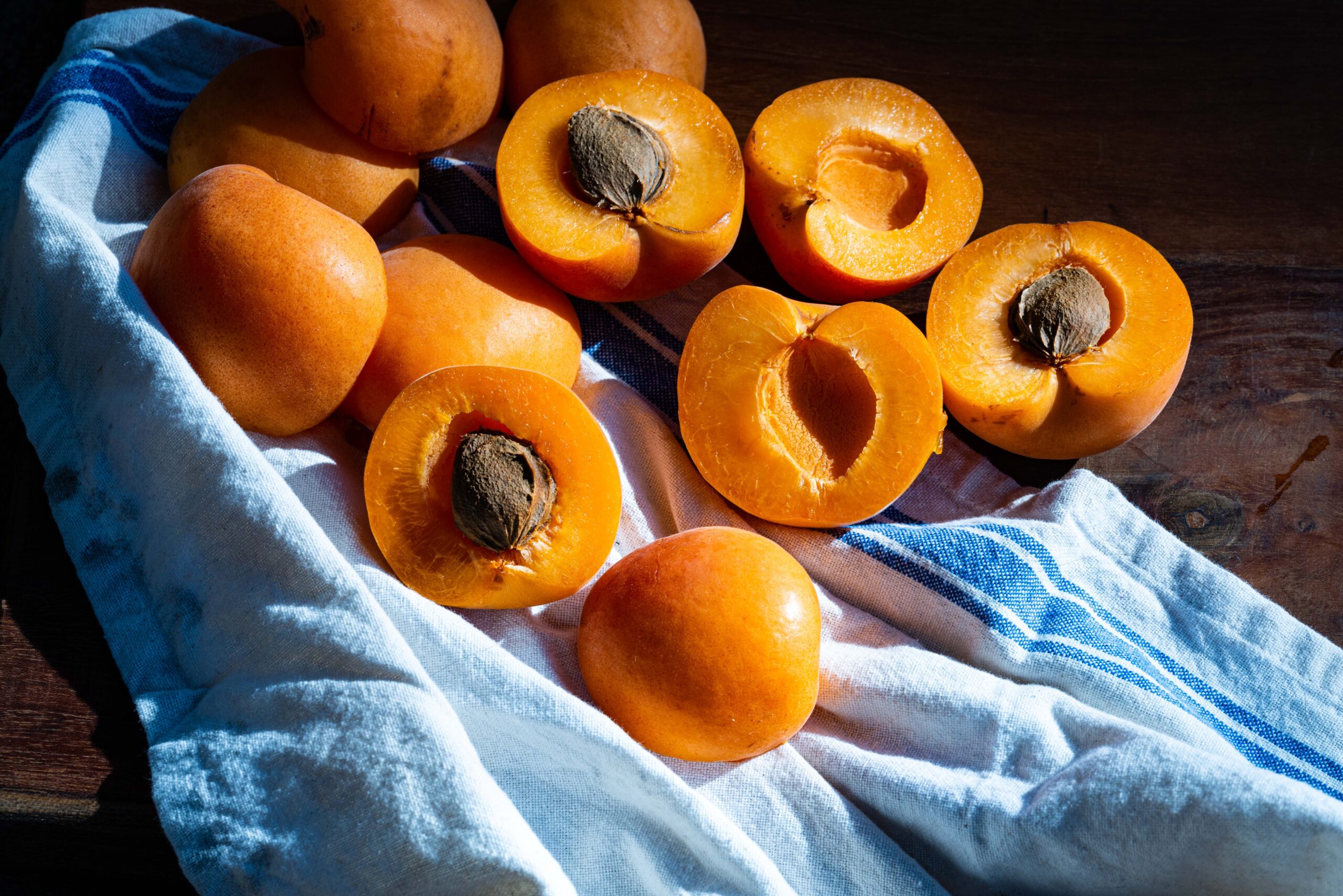 Fresh apricots cut in half showing apricot kernels inside, a natural source of Vitamin B17 foods