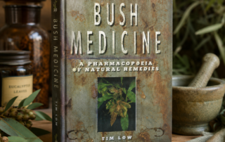 Tim Low's Bush Medicine: A Pharmacopoeia of Natural Remedies, displayed on a wooden surface surrounded by apothecary-style glass jars, dried herbs, a stone mortar and pestle, and neutral linen cloth
